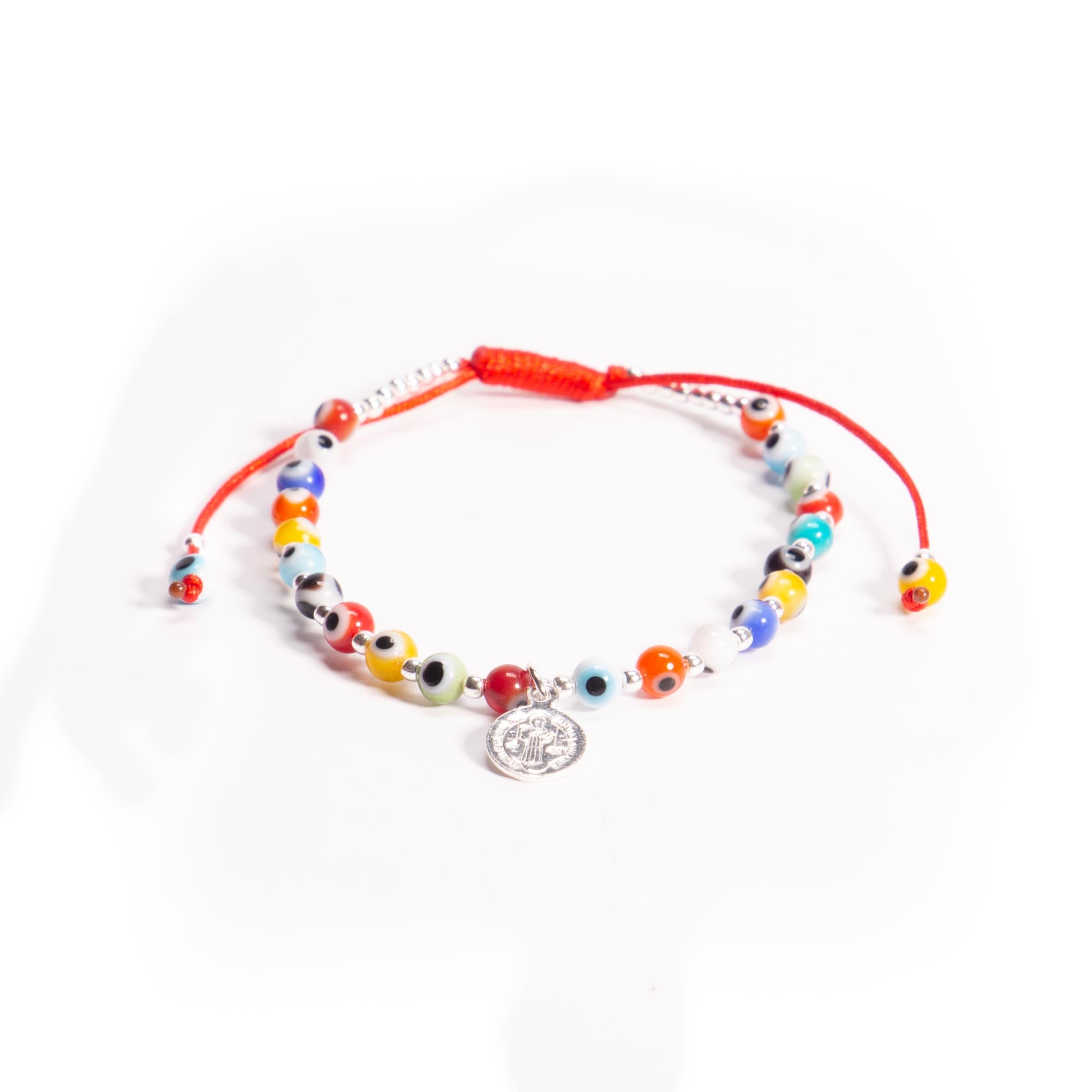 Pulsera de hilo con dije de San Benito de plata y ojos turcos